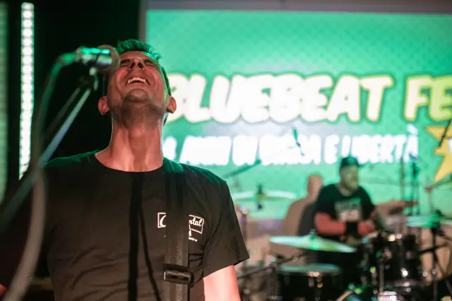 Maurizio canta davanti allo schermo del Bluebeat Fest